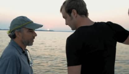 two men standing by the water